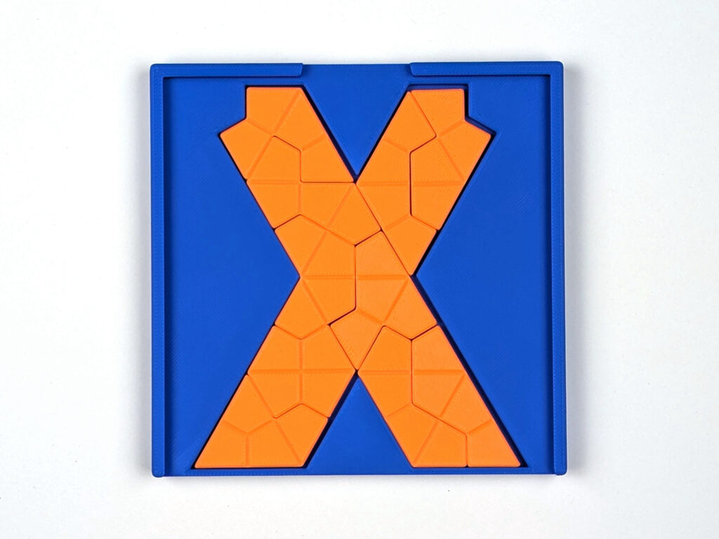 3D-gedrucktes X-Puzzle aus zehn Waben-Tetrakites in einer blauen Box